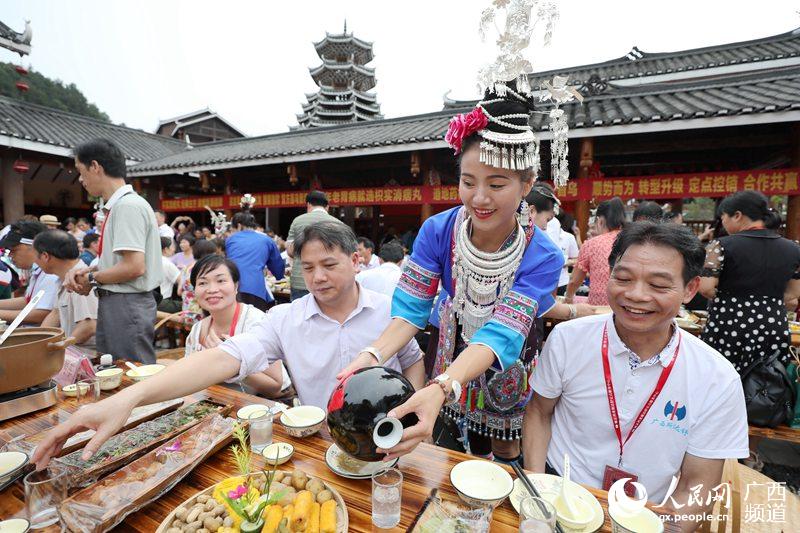 7月9日,在三江侗族自治县侗乡鸟巢,一名侗族女子在摆百家宴.龚普康摄