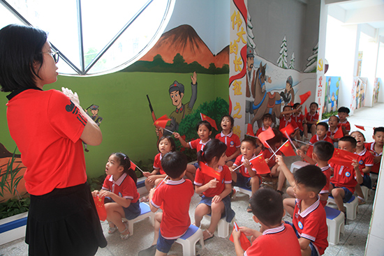 教师教孩子们唱红色歌曲《闪闪的红星》。林诗��摄