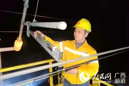 姜新鬆對接觸網設備進行檢修。柳州供電段供圖