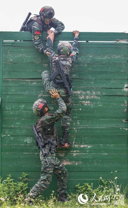 武警特戰隊員進行三人合作攀登訓練。果志遠攝