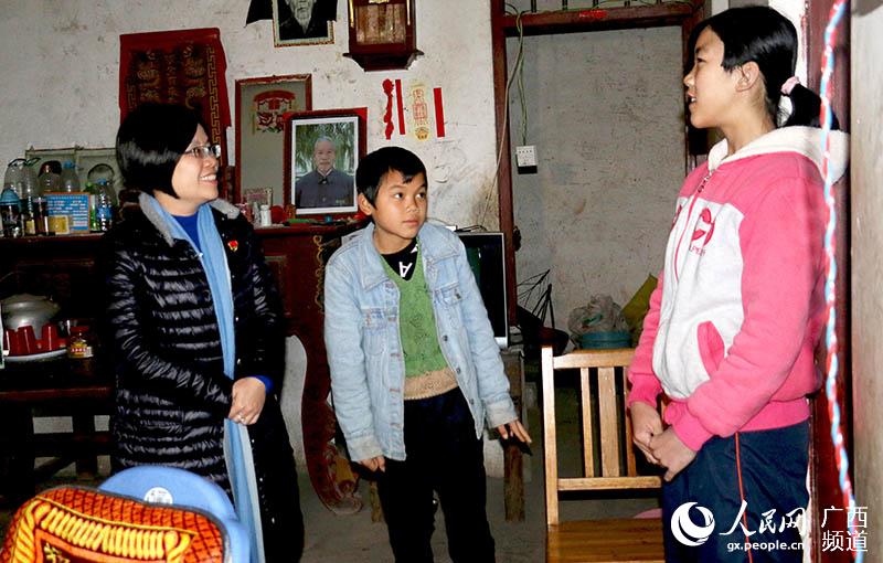鐘山縣長陳書瑩在清塘鎮大同村委廟六村困難黨員家中了解孩子們的學習生活情況。廖超文攝