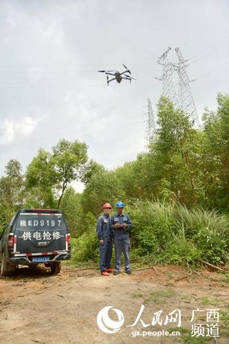 输电运维人员使用无人机对线路进行巡视。阳文志摄