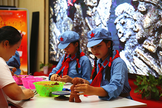 田东县城北小学师生还现场表演制作“红色印记”泥塑。中共百色市委组织部供图