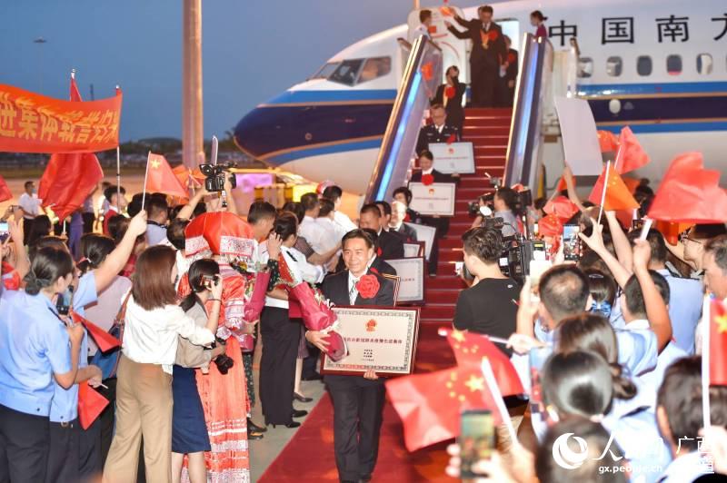 廣西獲表彰先進個人和集體代表在南寧吳圩國際機場受到熱烈歡迎。鄧華攝