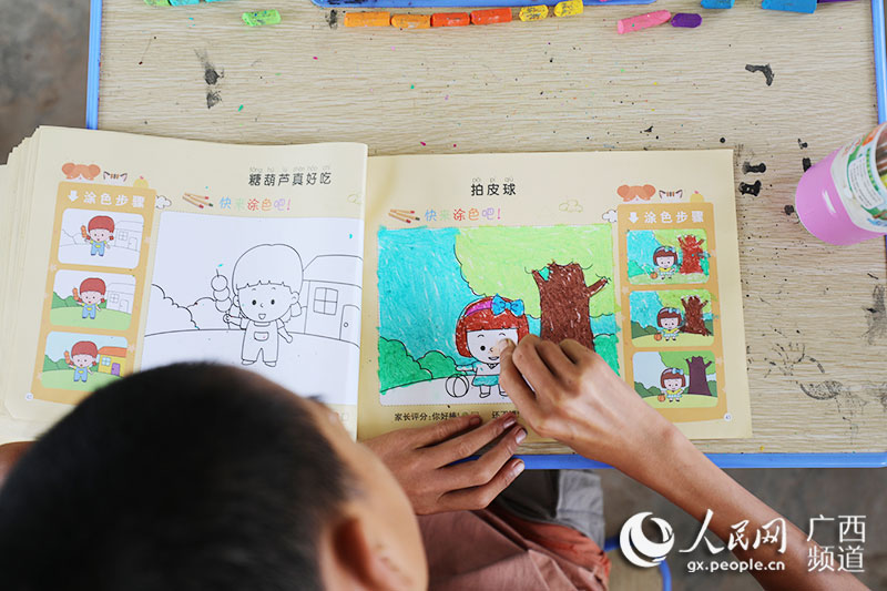 黃華興在認真地畫畫。韋世仙攝
