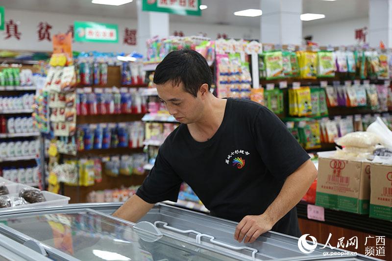 建檔立卡貧困戶莫榮桂到超市就業，月收入近3000元。張志成攝