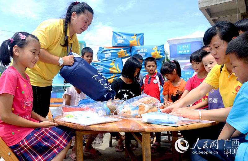 志願者為燕塘鎮旗嶺腳村遭受洪水災害家庭的少年兒童發放壹基金救災溫暖包。廖超文攝