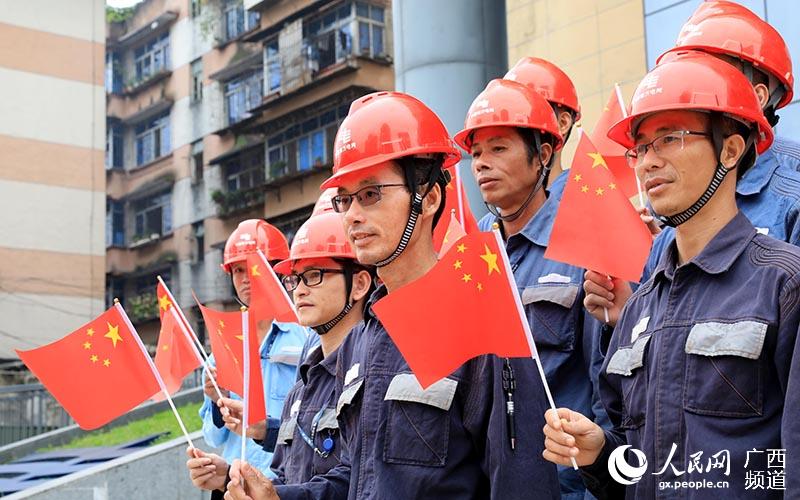 9月25日，南方電網廣西柳州融安供電局的工人們與國旗合影。覃慶和攝