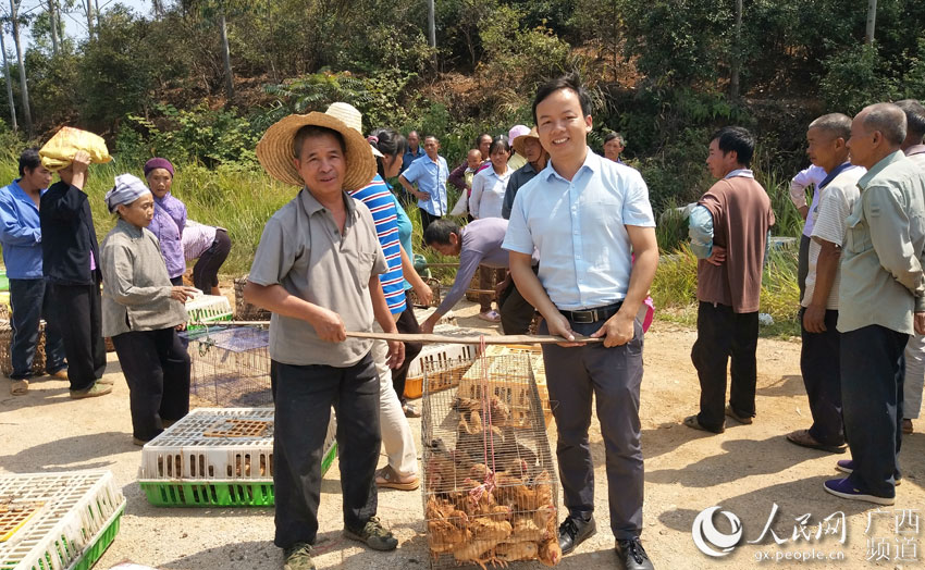 周党（前排右一）向养殖户发放鸡苗。黄绍源摄