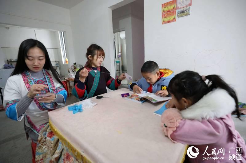 兩名繡娘在三江侗族自治縣古宜鎮南站社區家裡刺繡。龔普康攝