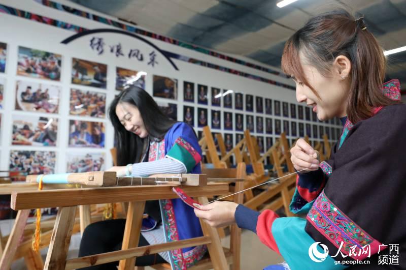 兩名繡娘在三江侗族自治縣古宜鎮南站社區一家繡坊內刺繡。龔普康攝
