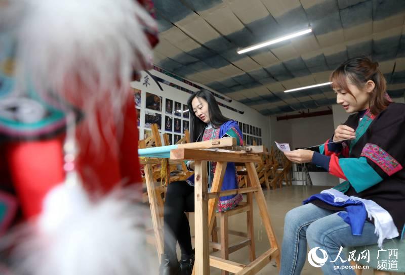 兩名繡娘在三江侗族自治縣古宜鎮南站社區一家繡坊內刺繡。龔普康攝