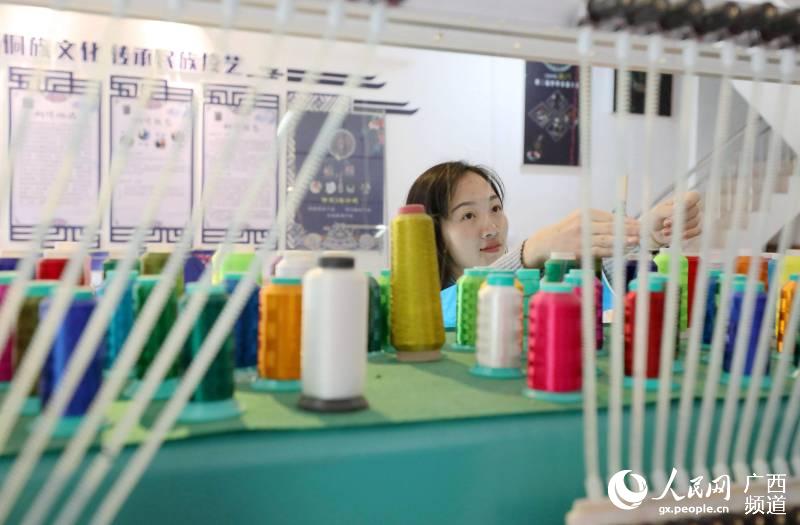 兩名繡娘在三江侗族自治縣古宜鎮南站社區一家繡坊內管理機繡機器。龔普康攝