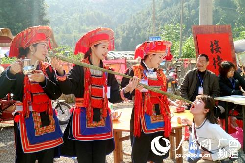 圖為瑤族同胞向客人敬酒。梁春梅攝