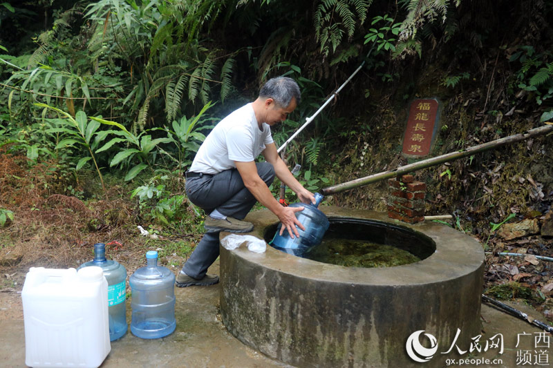 旺步村福龍長壽泉泉水清甜干淨，吸引市民前來打水。莫潔月攝