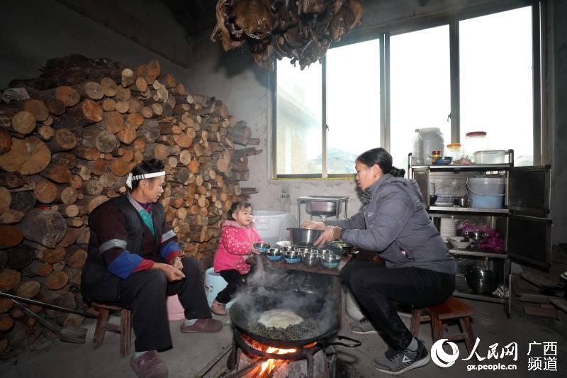 在三江侗族自治縣良口鄉燕茶村，一名婦女在挂滿臘鴨的火塘邊打油茶。龔普康攝