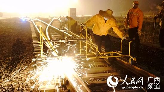玉林工務段職工在夜間線路上利用打磨機進行打磨鋼軌肥邊作業。譚育俊攝