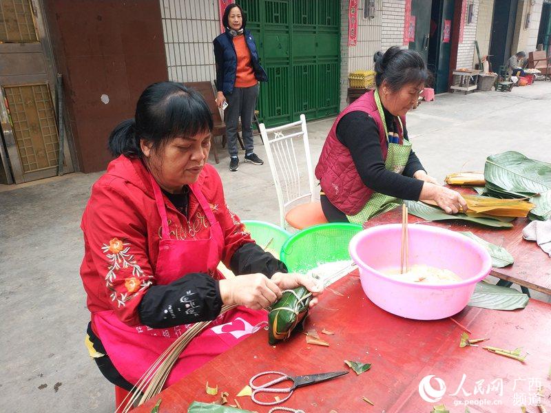 1月31日，寧明縣城中鎮明陽小區居民群眾正在認真包年粽准備過年。周貽剛攝