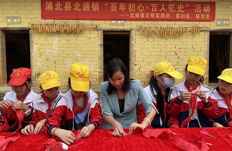 北通鎮黨委書記黃燕和學生一起制作小紅花。黃廷國攝