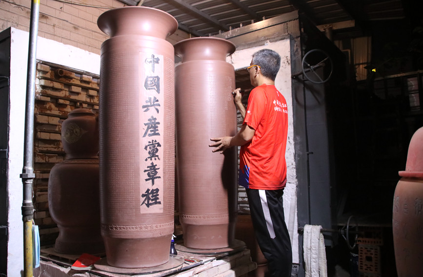 圖為韓志偉在坭興陶上刻黨章。毛麗婷攝