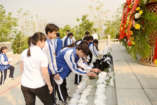 青年學生向烈士敬獻小白花。西林縣委宣傳部供圖