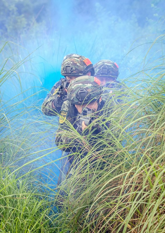 武警官兵利用煙霧彈掩護搜索前進。