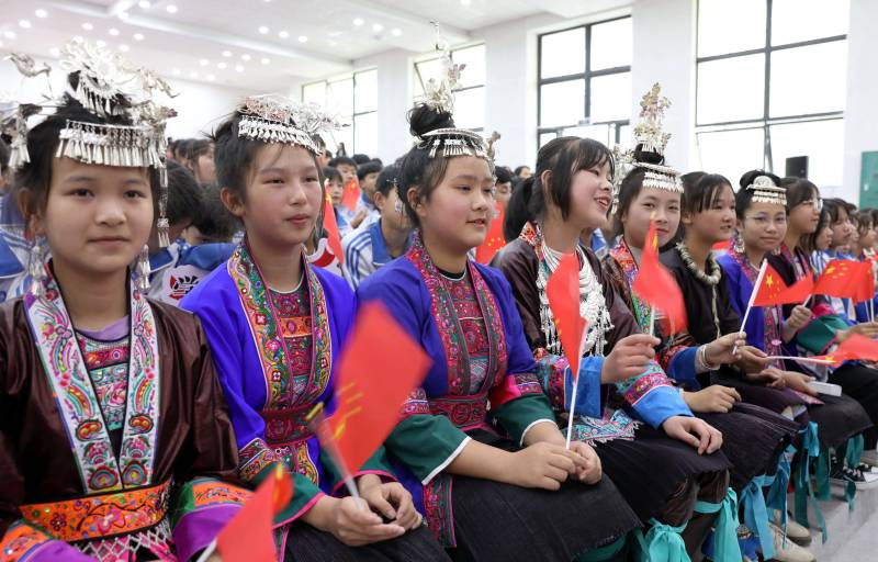 身著民族服裝的小姑娘們在觀看比賽。龔普康攝