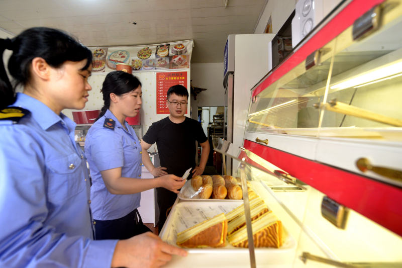 圖為執法人員抽檢蛋糕店。滾億忠攝