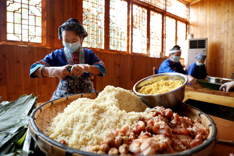在廣西三江侗族自治縣斗江鎮牙林村小龍勝屯，侗族婦女們正在包粽子。吳練勛攝