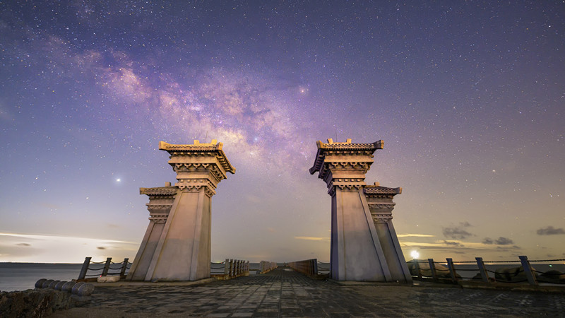 在广西钦州市三娘湾景区,夜空中的银河与海湾相互辉映.朱智摄