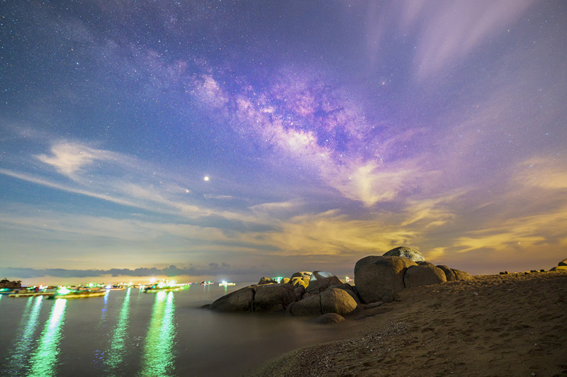 在广西钦州市三娘湾景区,夜空中的银河与海湾,礁石相互辉映.朱智摄