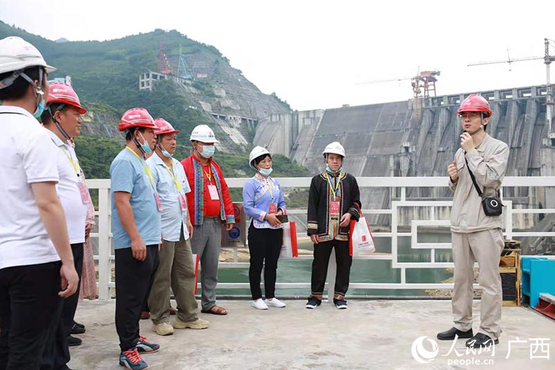 在龙滩水力发电厂主坝前,电厂职工向来宾讲解龙滩水利枢纽工程的建设