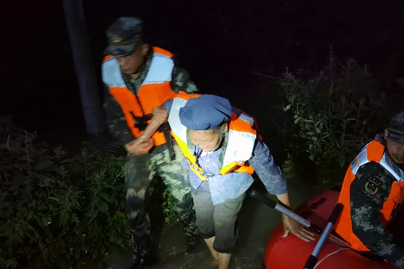武警官兵夜間轉移行動不便的老人前往安置點。