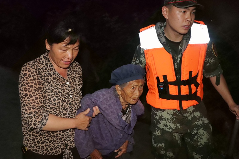 武警官兵夜間轉移行動不便的老人前往安置點。