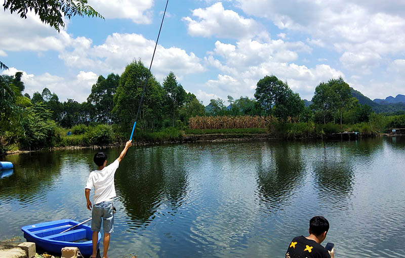 游客在江台村香樟公園池塘邊垂釣。廖超文攝