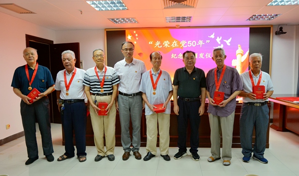 陈立同志（左五）获得“光荣在党50周年”纪念章。玉林市发展和改革委供图。