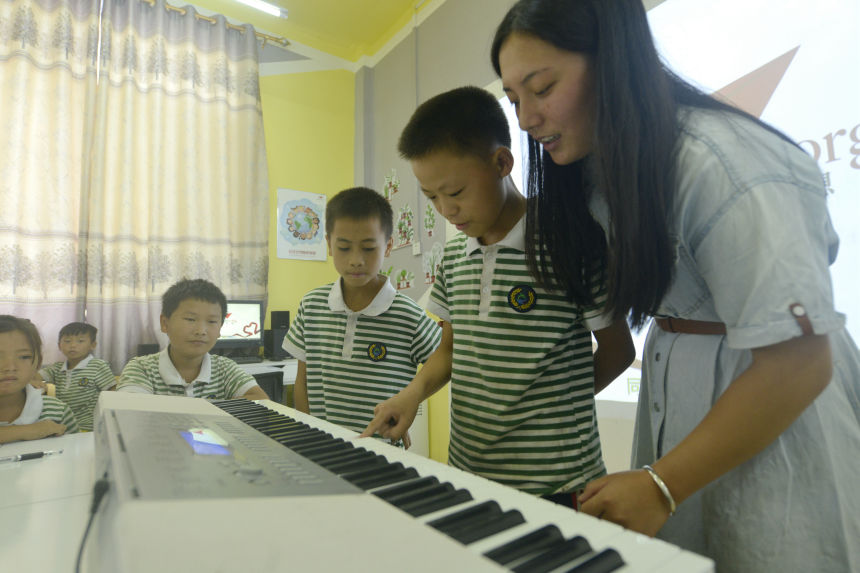 圖為教師指導孩子們學習電子琴。滾億忠攝