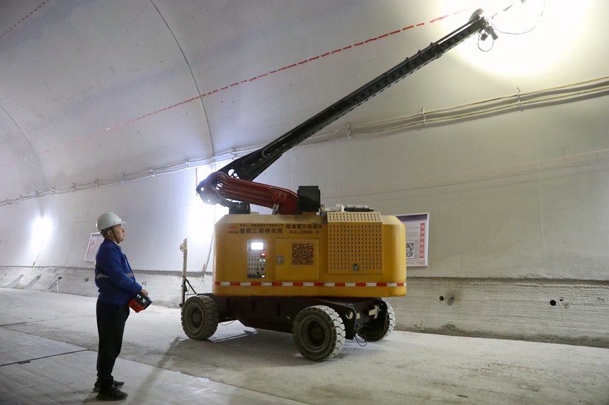 施工人員操縱新研發的隧道二襯自動雷達檢測車對隧道二襯混凝土質量進行檢測。