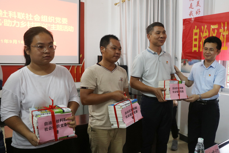 杨东星(右一)向锦江村委赠送科普书籍。黄建年摄