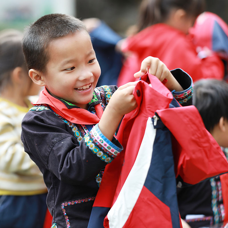 孩子们兴高采烈地换上新衣。胡俊摄