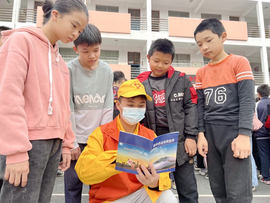 青年志願者在給小學生互動講解鐵路春運安全知識和人身安全保護條款。鄭宇彤攝