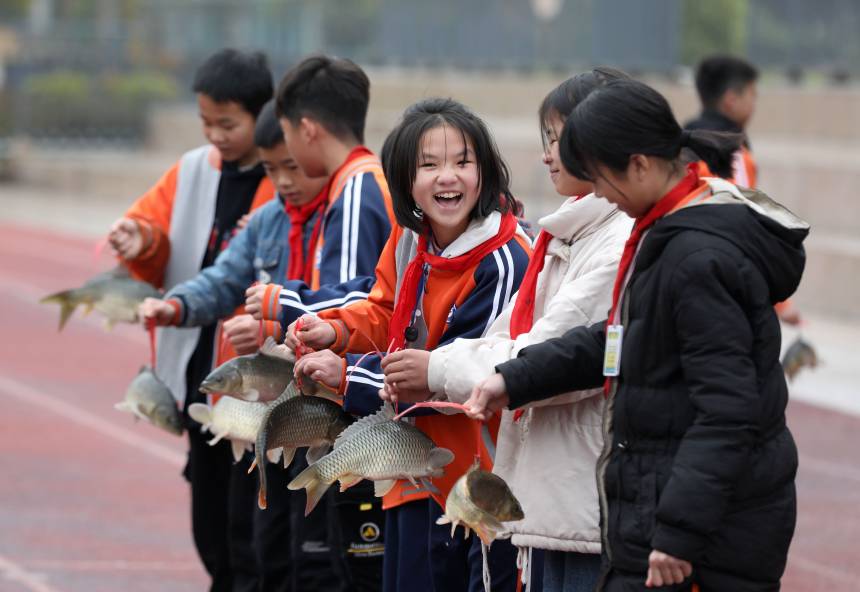 學生們領到“鯉魚獎品”后開心地笑著。龔普康攝