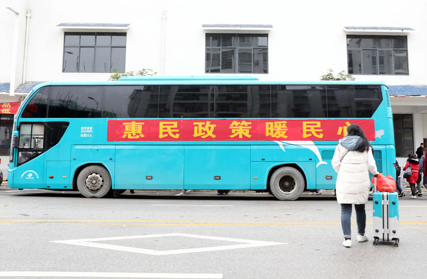 在融安县粤桂劳务合作工作站，一名外出务工人员准备登上返岗专车。