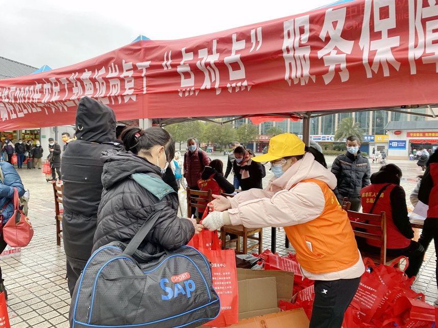志愿者为务工人员发放食物和饮用水。陈雨雨摄