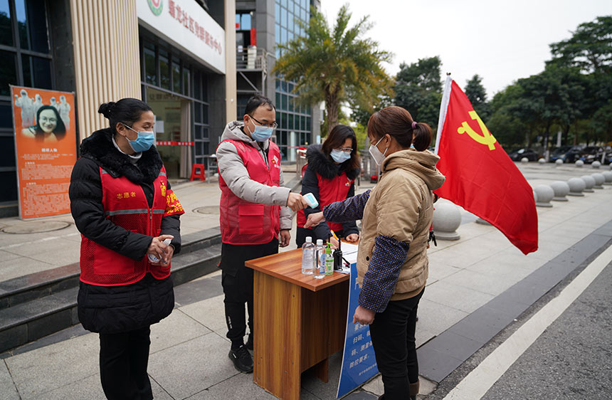 良慶區鎮蟠龍社區黨員先鋒崗正在對往來群眾進行體溫監測。良慶區融媒體中心供圖
