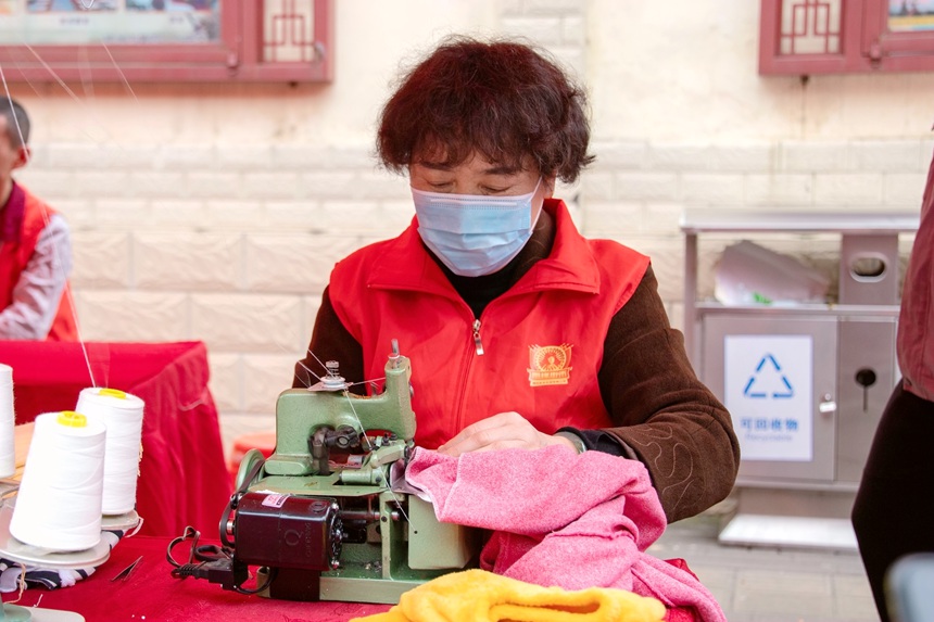 志愿者为市民提供缝纫服务。刘坤摄