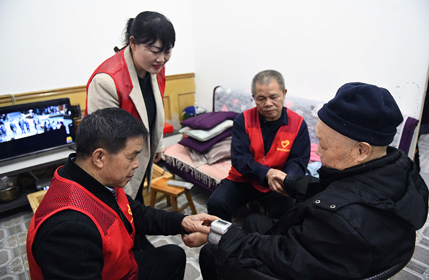 3月4日，在广西龙胜各族自治县龙胜镇城南社区，志愿者给老人测量血压。
