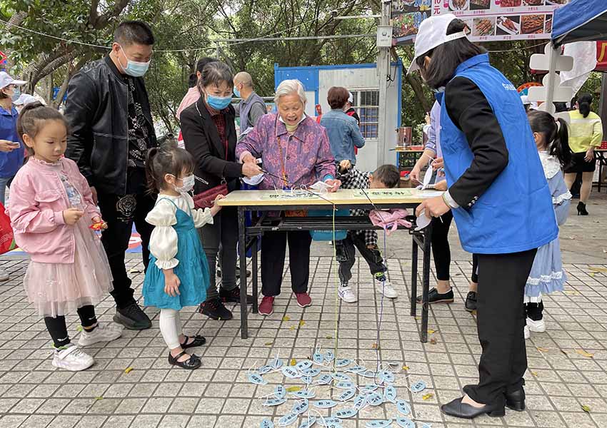 志愿者指导居民参加禁毒知识小游戏。滕美专摄