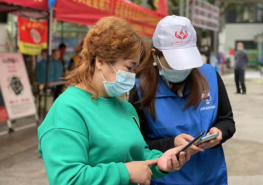 志愿者教市民使用微信公众号。滕美专摄