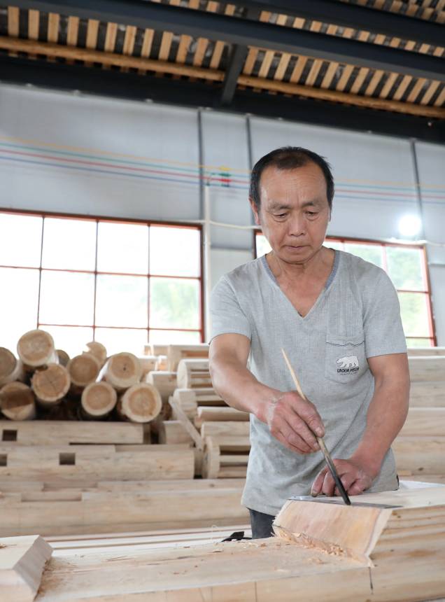 一名侗族工匠在加工木料。龔普康攝